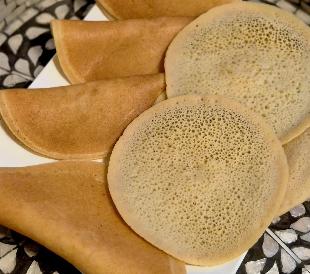 A serving plate with several round Moroccan pancakes "Beghrir"