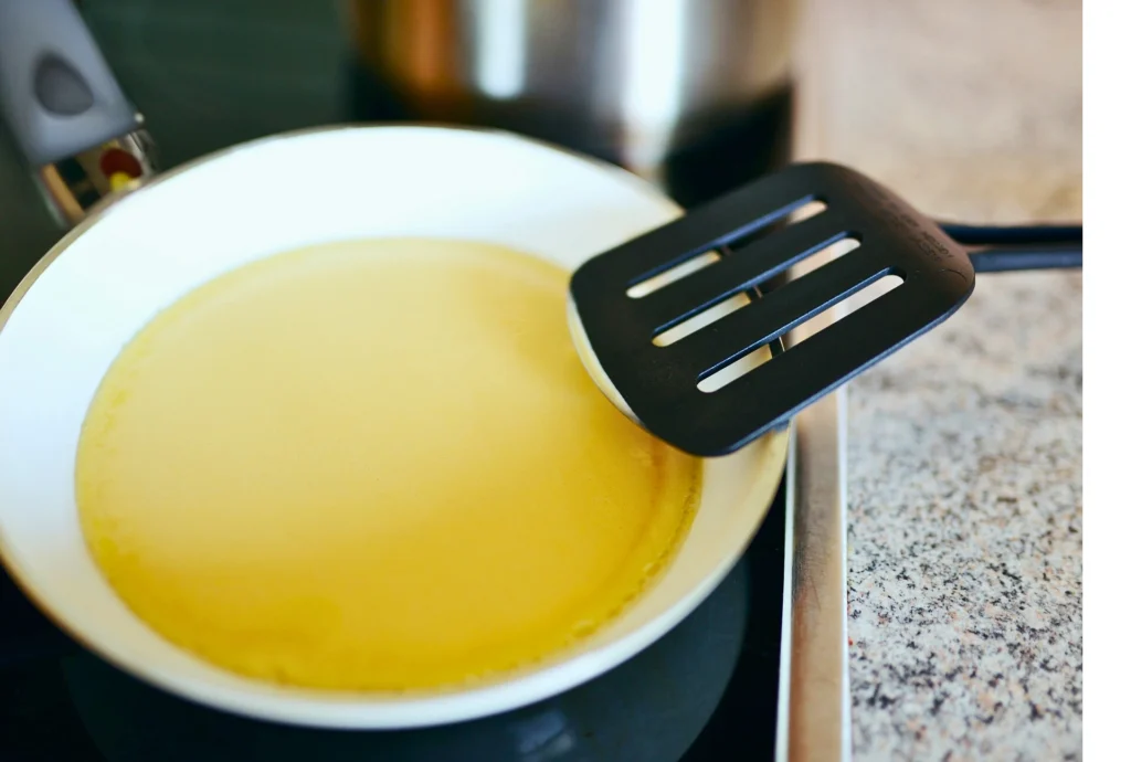 pouring pancake batter into a hot cast iron skillet